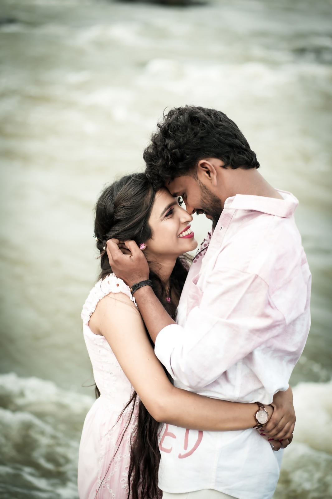 Atul and Mansi embracing beside the water during their pre-wedding shoot