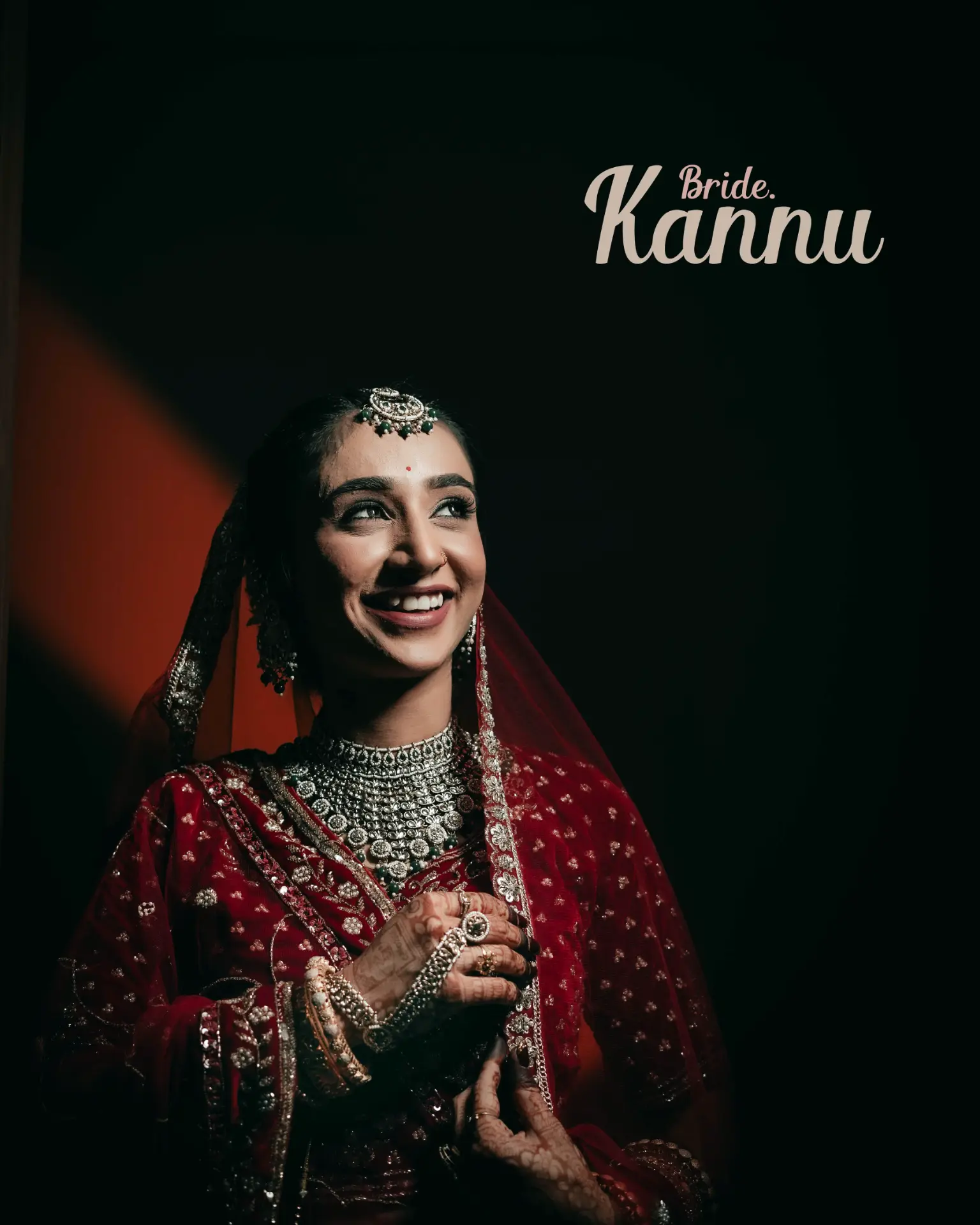 Bride Kannu smiling in traditional red wedding attire