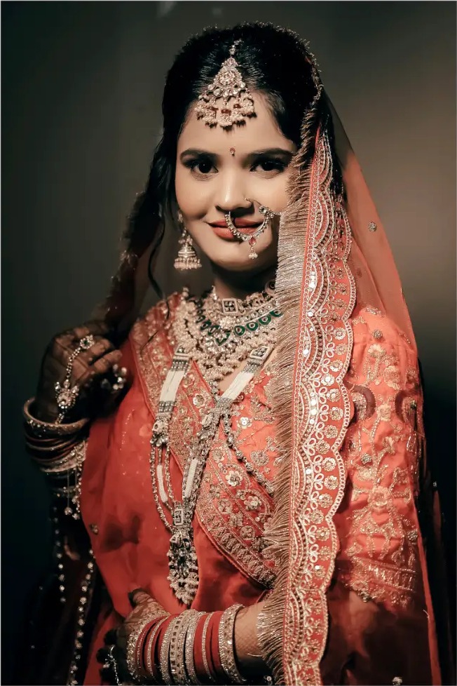 Editorial bridal portrait of Priya in a coral lehenga