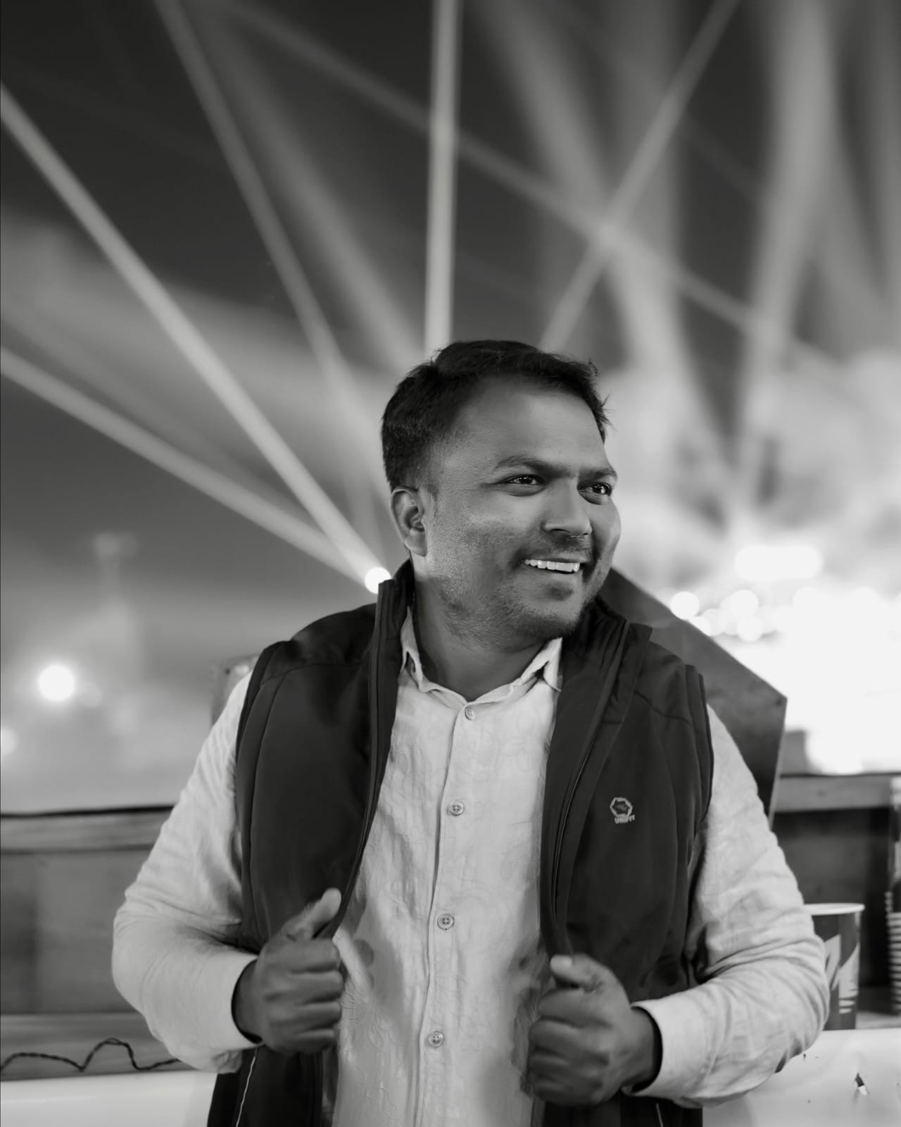 Black and white portrait of Manoj Badoliya smiling at night
