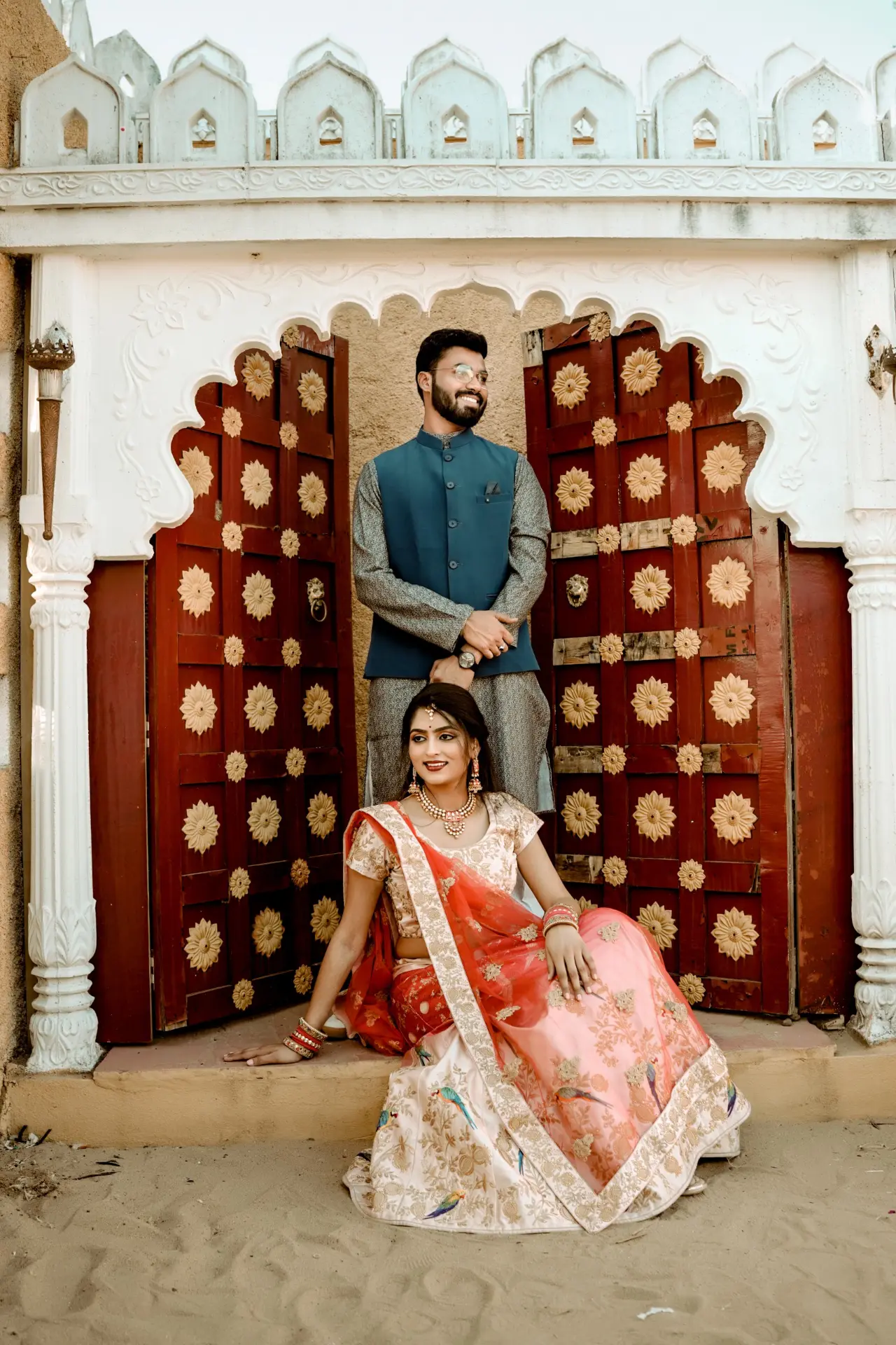 Pre-wedding portrait of a couple at a traditional carved doorway