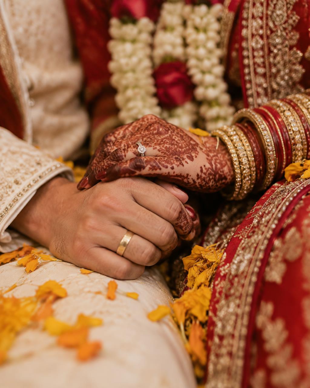 Close-up of the couple's hands with wedding rings